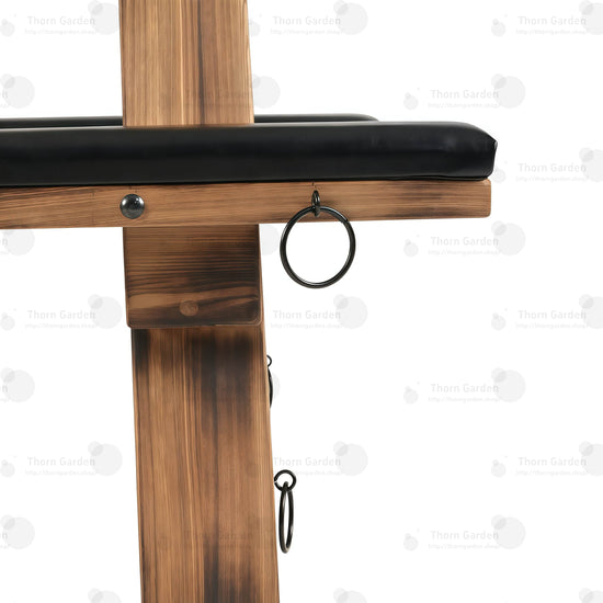 Close-up of black metal side anchor ring mounted on solid wood beam with heavy-duty rivets