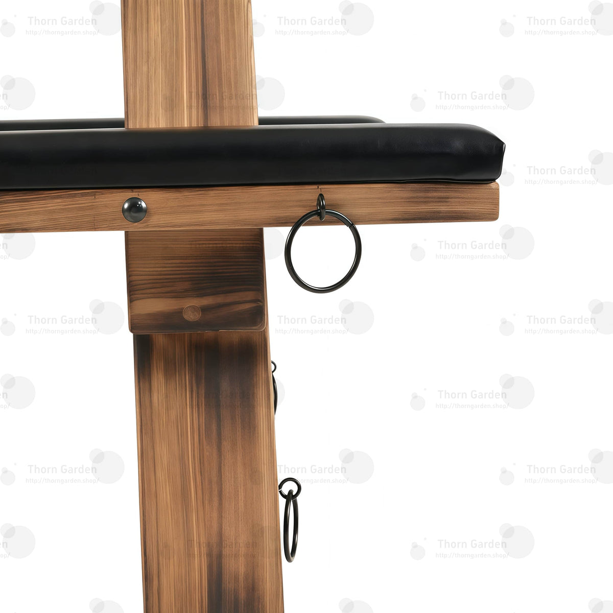 Close-up of black metal side anchor ring mounted on solid wood beam with heavy-duty rivets
