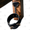 Interior view of U-shaped open-front wooden seat plate and ankle restraint cuffs on bottom chair legs