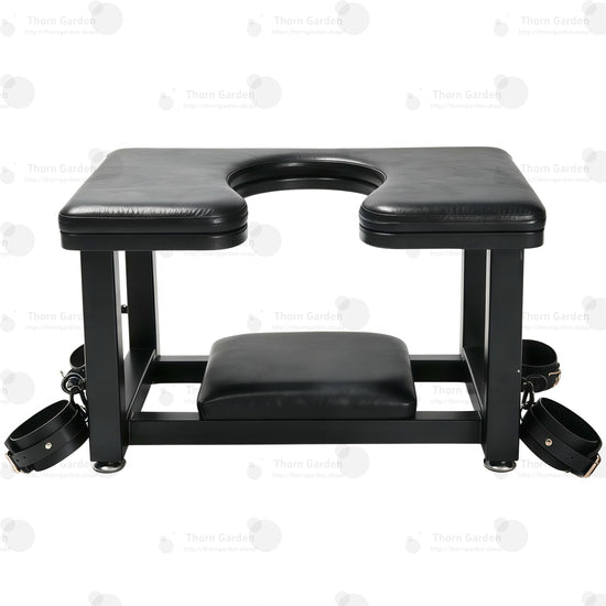 Full front view of premium leather queening chair with U-shaped cutout seat, black steel frame, bottom headrest, and restraint cuffs