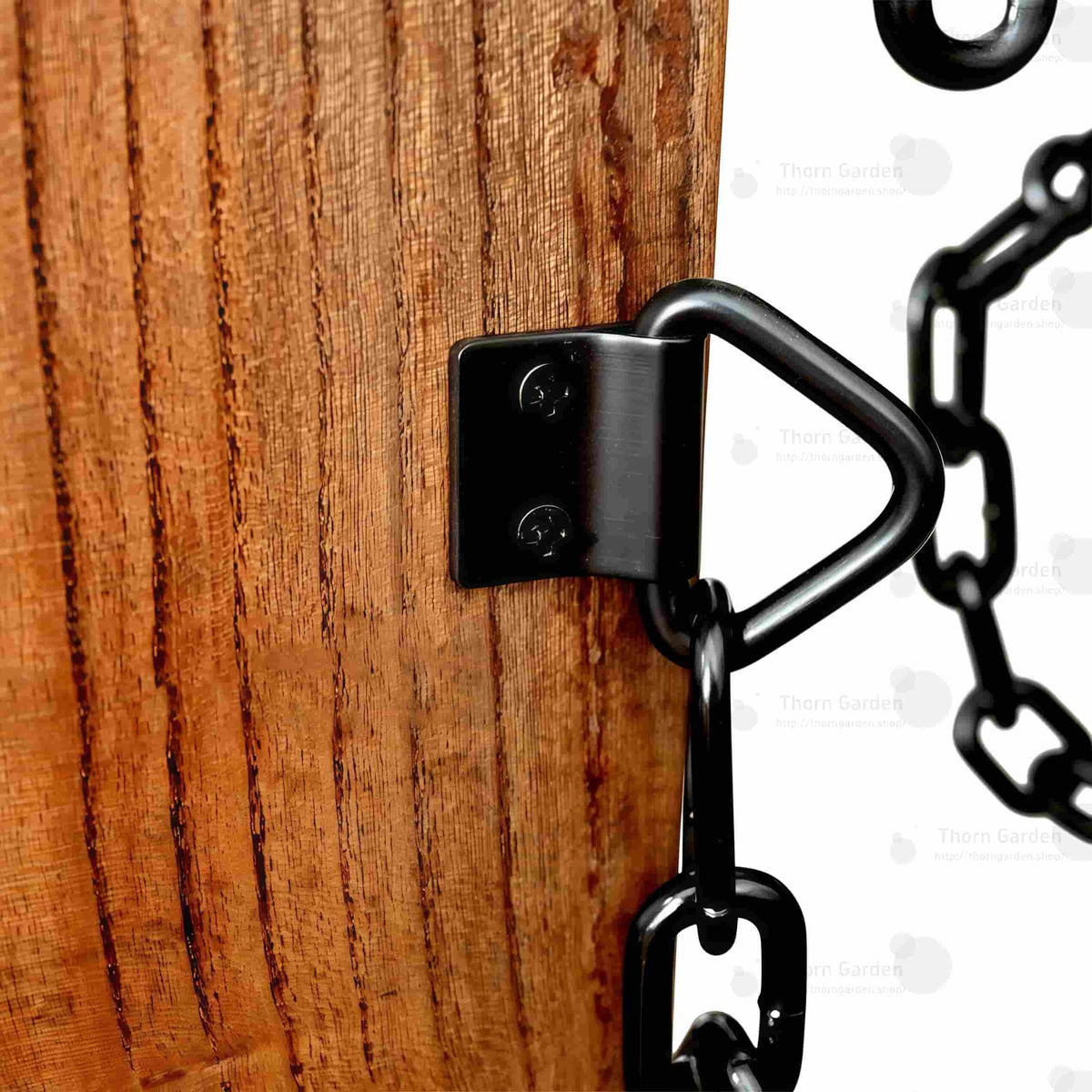 Detail of hand-carved wooden armrests equipped with black metal restraint chains and leather wrist cuffs