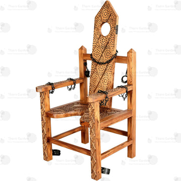 Full view of solid wood torture bondage armchair with hand-carved spiked texture, neck hole, chains, and restraints