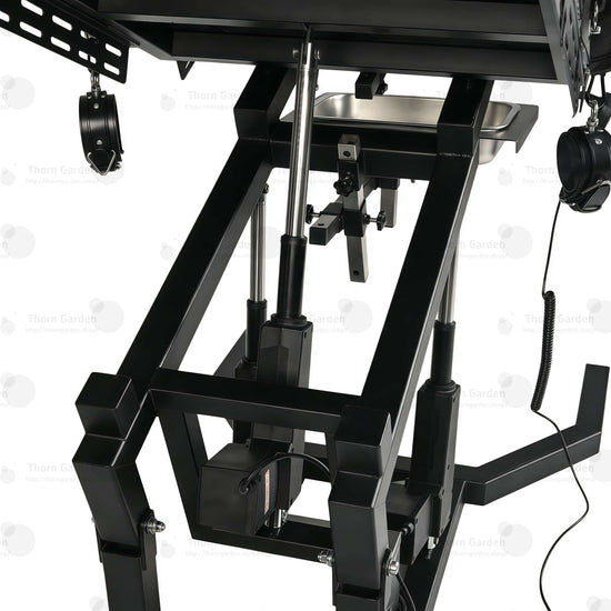 Close-up of electric lift actuator mechanism, control box, and handheld remote controller on gyno examination bondage chair