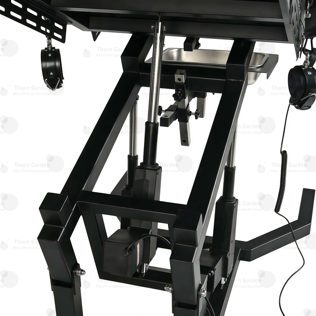 Close-up of electric lift actuator mechanism, control box, and handheld remote controller on gyno examination bondage chair
