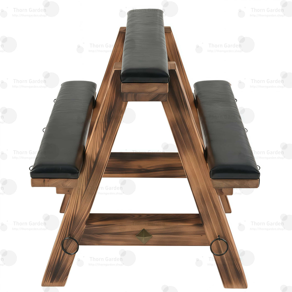 Three-quarter view of solid wood bondage horse bench with black leather padded cushions, torched wood finish, and metal anchor rings