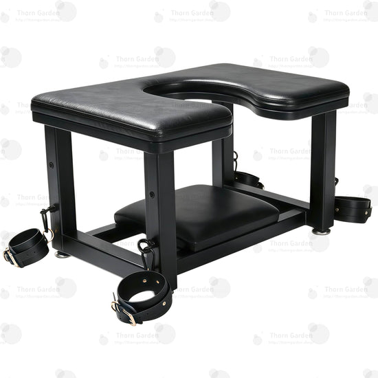 Full front view of premium leather queening chair with U-shaped cutout seat, black steel frame, bottom headrest, and restraint cuffs