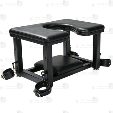 Full front view of premium leather queening chair with U-shaped cutout seat, black steel frame, bottom headrest, and restraint cuffs