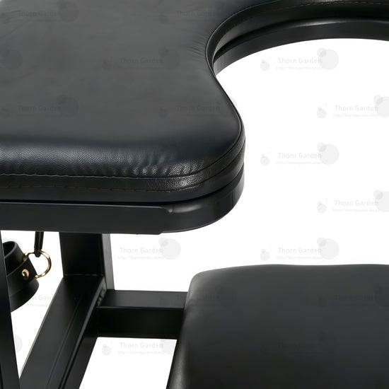 Nærbilde av et førsteklasses, svart, polstret skinnsete med nøkkelhullutskjæring og kraftige sømmer