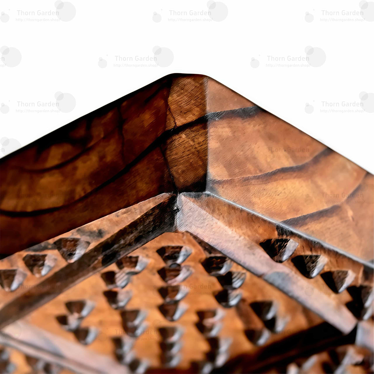 Close-up van een hoge, puntige houten rugleuning met ronde nekopening, een textuur met studs en spikes en metalen kettingen