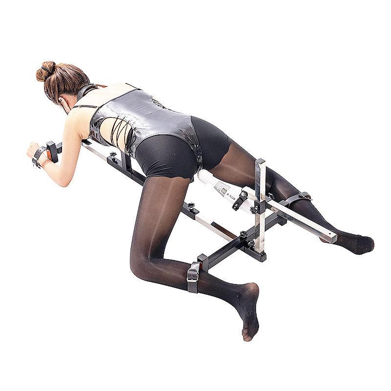 Studio product model rear view of the THORN GARDEN 3G Bondage Stockade with metalcuffs showcasing a model secured in a four-limb restraint rack with an electric sex machine against a clean background