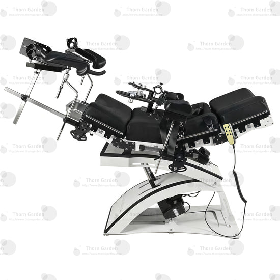 Studio product top overview view of the THORN GARDEN Electric Gyno Bondage Chair Custom showcasing the complete upper restraints, gynecological stirrups, and remote controller against a clean white background